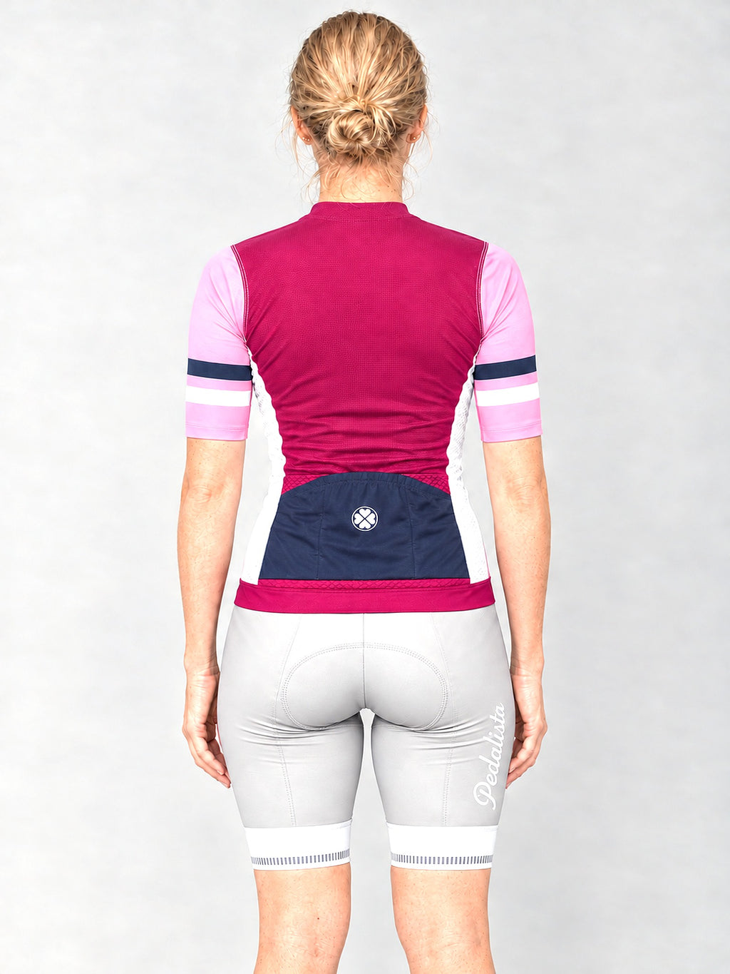 Model wearing the Pink Attack jersey with silver bib shorts, back view