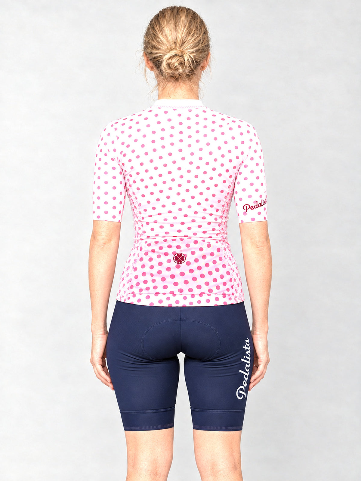 Model wearing the Queen of the Mountain jersey with navy bib shorts, back view