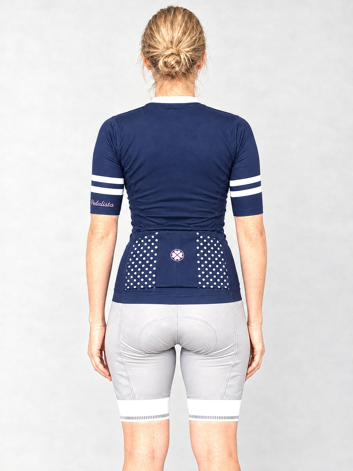 Model wearing The Jackie jersey with silver bib shorts, back view